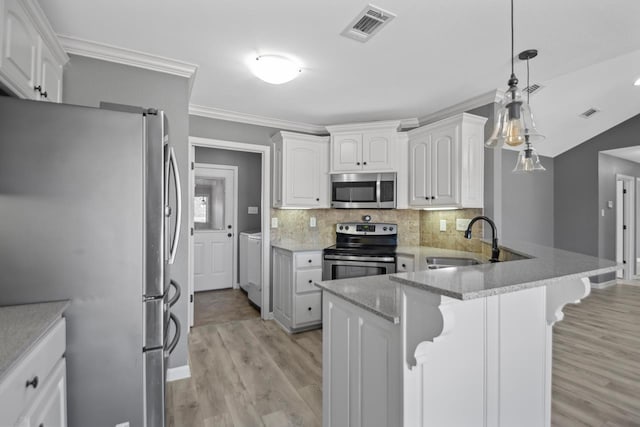 kitchen featuring white cabinets, appliances with stainless steel finishes, decorative light fixtures, backsplash, and kitchen peninsula