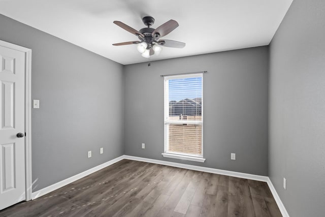 spare room with ceiling fan and dark wood-type flooring