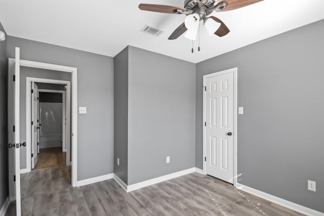 unfurnished bedroom featuring ceiling fan, hardwood / wood-style flooring, and a closet