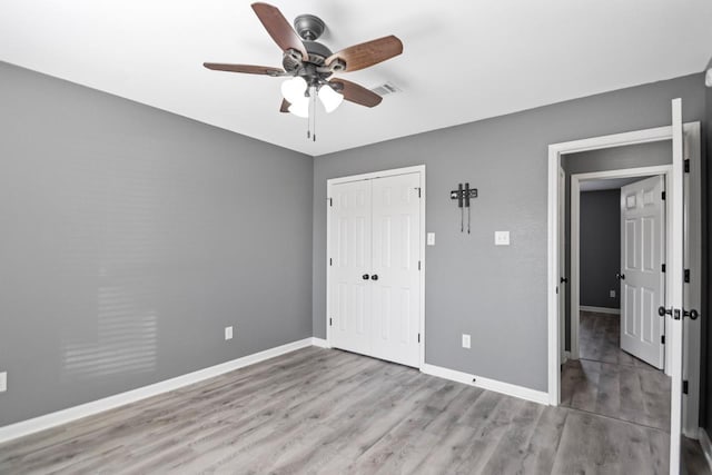 unfurnished bedroom featuring ceiling fan, a closet, and light hardwood / wood-style flooring