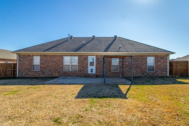 back of property with a patio area and a lawn