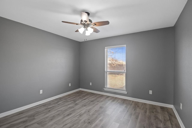 spare room with hardwood / wood-style flooring and ceiling fan