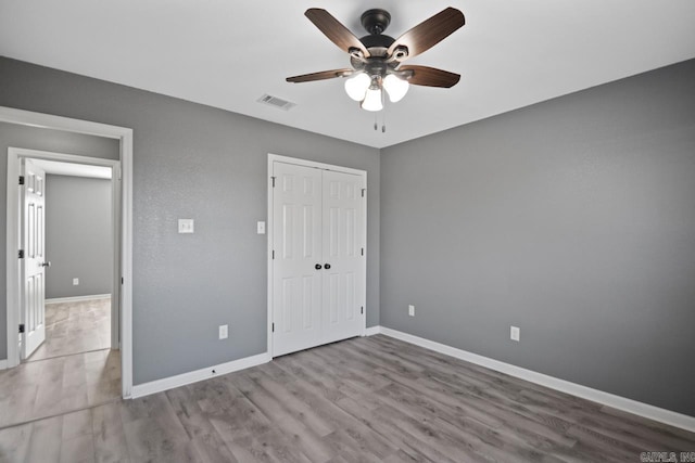 unfurnished bedroom with a closet, ceiling fan, and light wood-type flooring