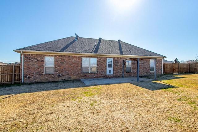 back of property with a lawn and a patio