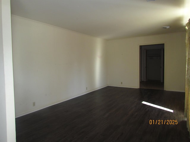 unfurnished room with dark wood-type flooring