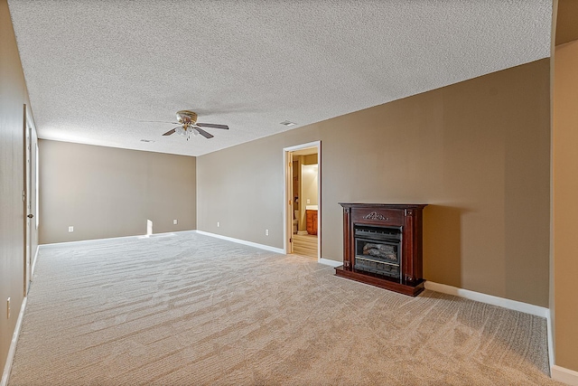 unfurnished living room featuring ceiling fan, light colored carpet, and a textured ceiling