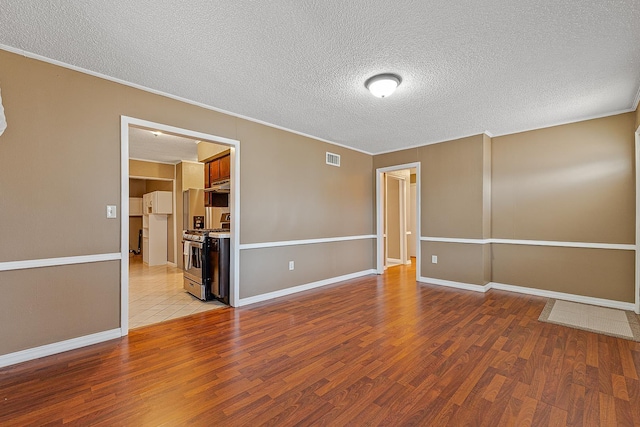 empty room featuring a textured ceiling and light hardwood / wood-style flooring