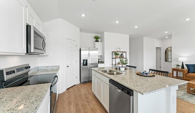 kitchen with sink, white cabinetry, stainless steel appliances, and a kitchen island with sink