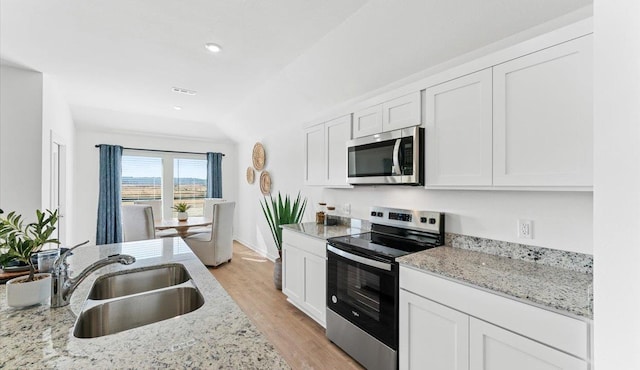 kitchen featuring sink, stainless steel appliances, white cabinets, and light stone countertops