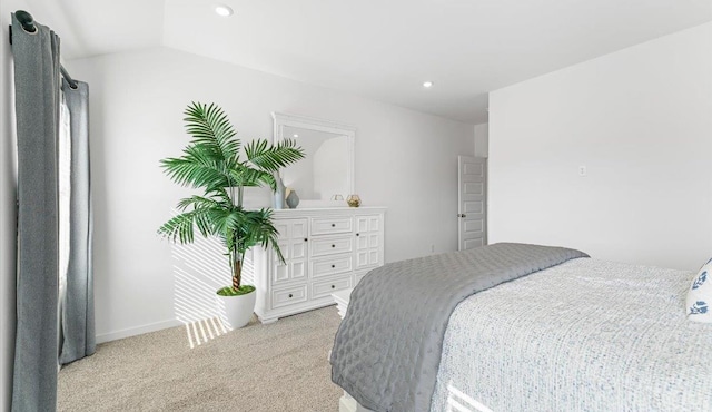 bedroom featuring lofted ceiling and light carpet