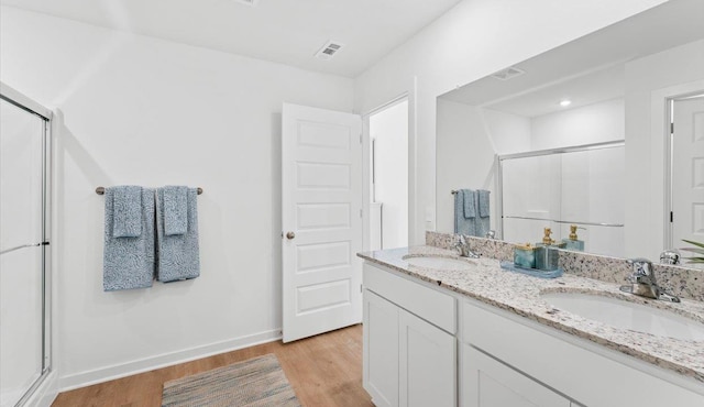 bathroom featuring hardwood / wood-style flooring, an enclosed shower, and vanity