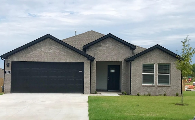 view of front of property with a garage and a front lawn