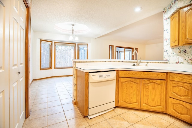 kitchen featuring white dishwasher, hanging light fixtures, light tile patterned floors, sink, and kitchen peninsula