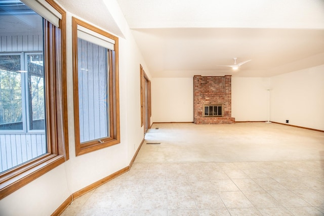 unfurnished living room featuring a fireplace, light colored carpet, and ceiling fan