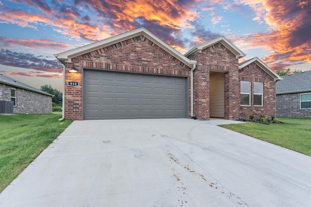 view of front of property featuring a garage, a yard, and cooling unit