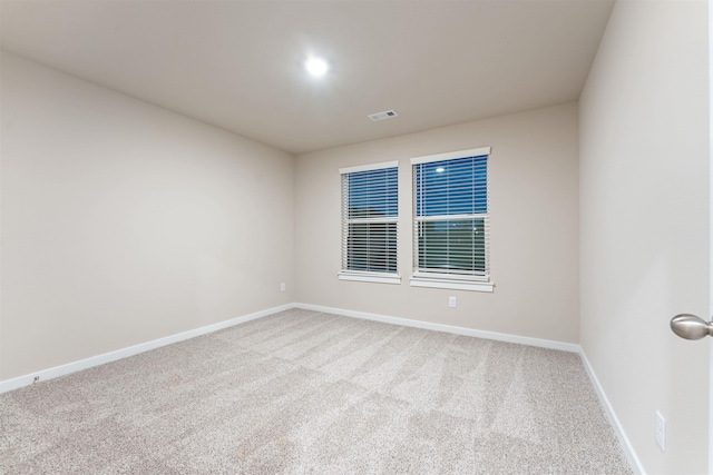 spare room with visible vents, carpet floors, and baseboards