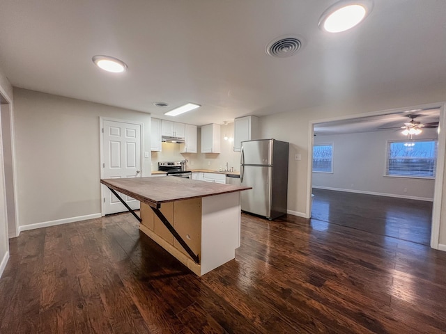 kitchen featuring dark wood-type flooring, white cabinetry, appliances with stainless steel finishes, and a kitchen island