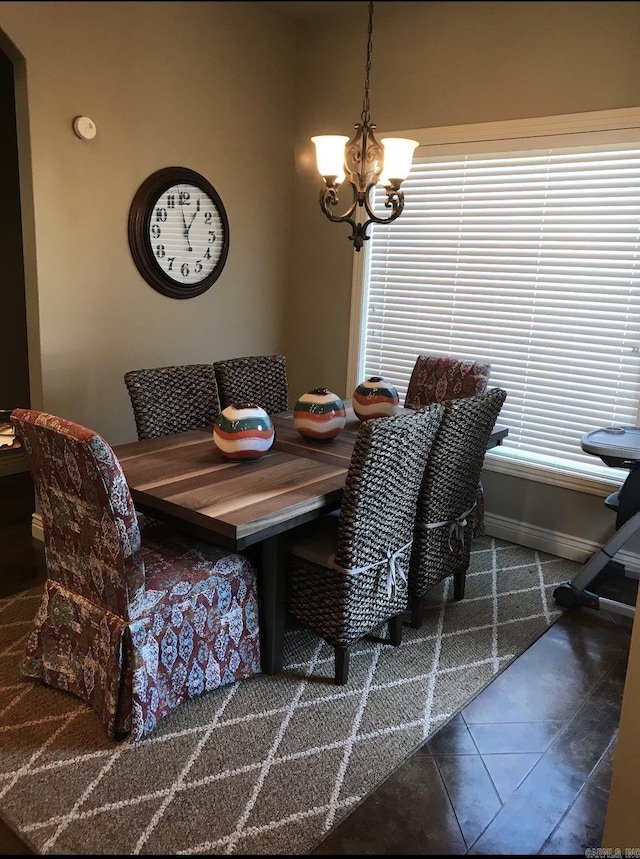 dining area with a notable chandelier and dark tile patterned floors