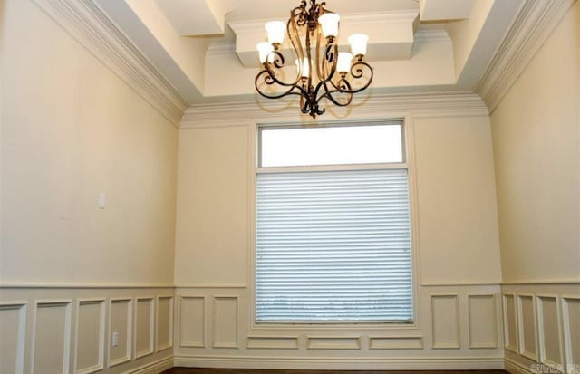 interior space featuring hardwood / wood-style floors, crown molding, and a chandelier