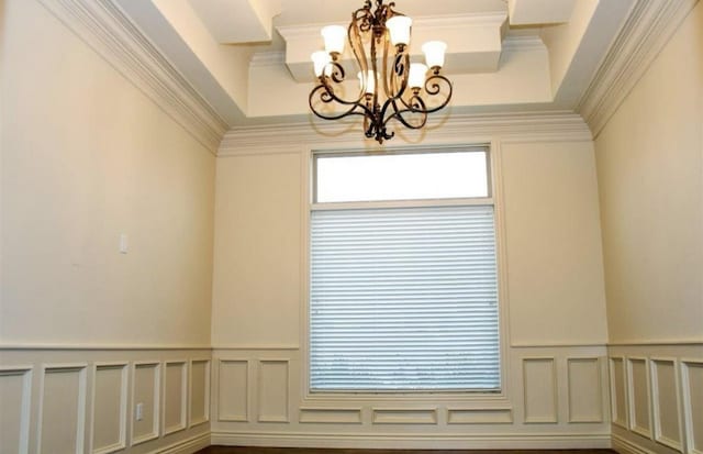 interior space featuring crown molding, hardwood / wood-style floors, and a chandelier