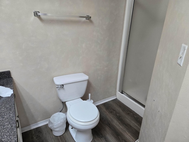 bathroom with toilet, hardwood / wood-style floors, and a shower with shower door