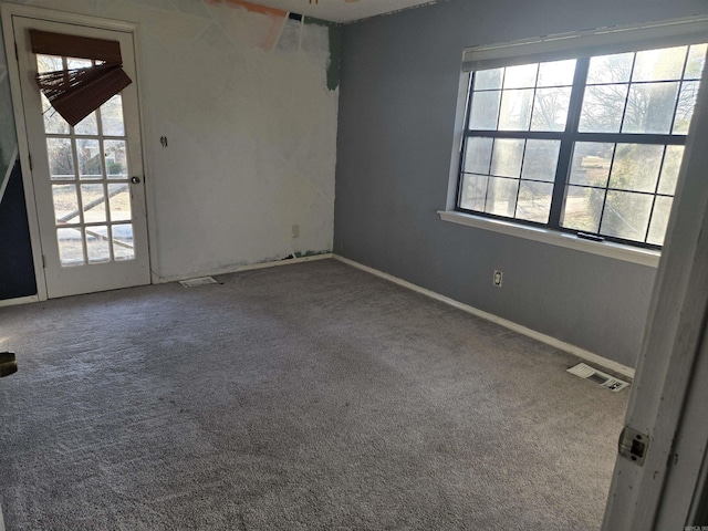 carpeted spare room featuring plenty of natural light