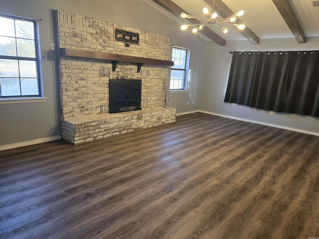 unfurnished living room with a fireplace, an inviting chandelier, beamed ceiling, and dark hardwood / wood-style flooring