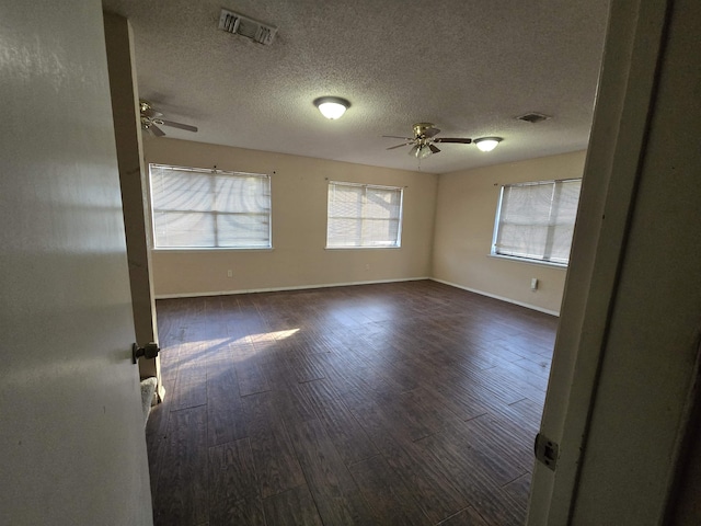 unfurnished room featuring ceiling fan, a textured ceiling, and dark hardwood / wood-style floors