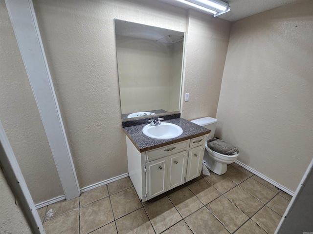 bathroom featuring tile patterned floors, vanity, and toilet