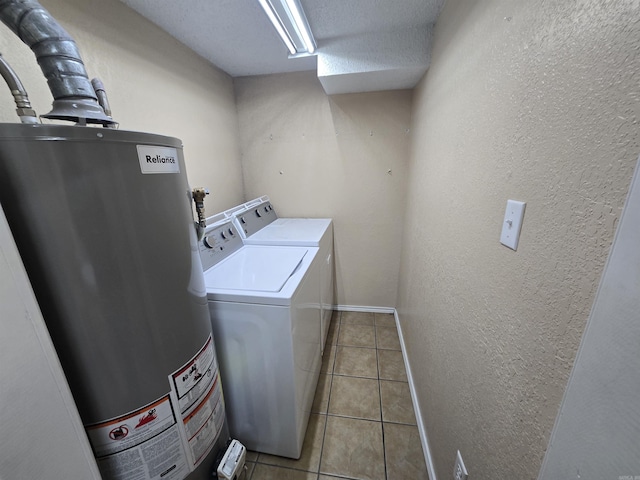 laundry area with light tile patterned flooring, water heater, and washing machine and dryer