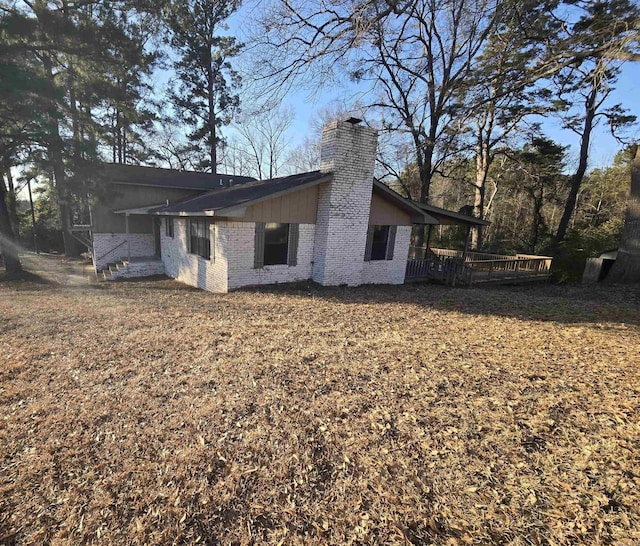 view of property exterior with a lawn and a deck