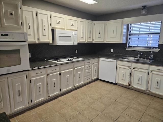 kitchen featuring sink, white cabinetry, white appliances, and light tile patterned floors