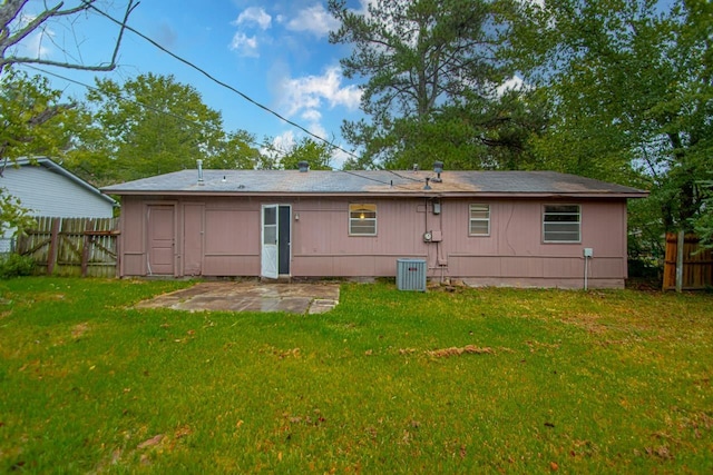 back of house featuring cooling unit, a patio, and a lawn