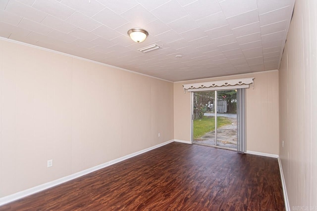 spare room featuring dark hardwood / wood-style floors and ornamental molding