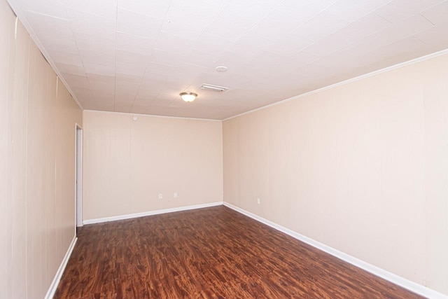 empty room with hardwood / wood-style floors and crown molding