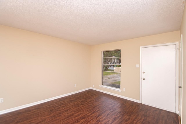 unfurnished room with dark hardwood / wood-style floors and a textured ceiling