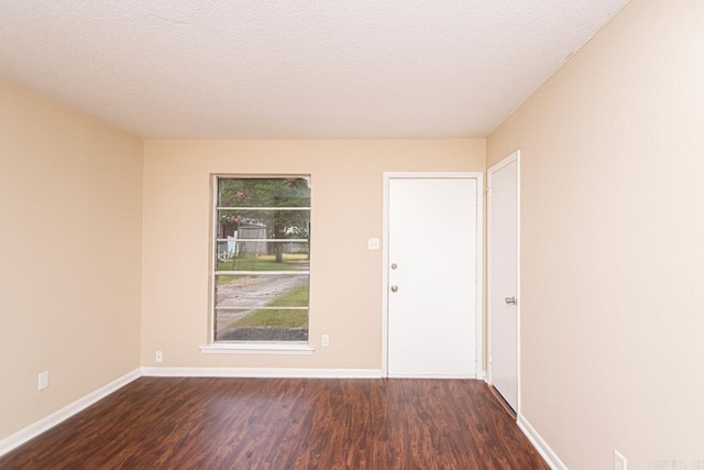 empty room featuring dark hardwood / wood-style floors and a textured ceiling