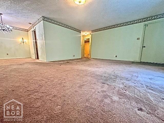 carpeted spare room with a textured ceiling