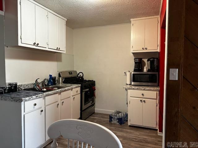 kitchen featuring a textured ceiling, white cabinetry, stainless steel appliances, sink, and dark hardwood / wood-style floors