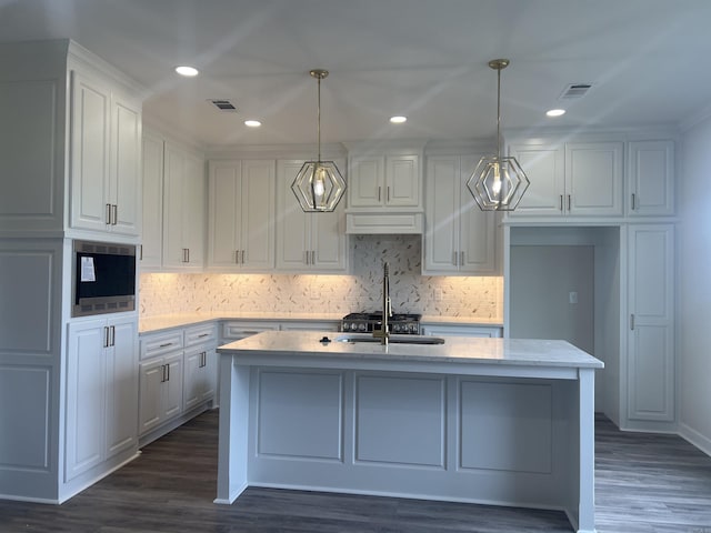 13510 Smarty Jones Dr, Scott, AR 72142 - kitchen featuring white cabinetry, built in microwave, a center island with sink, backsplash, and recessed lighting