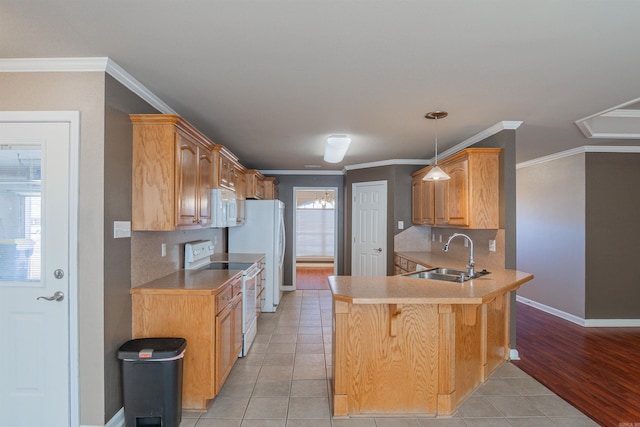 kitchen featuring kitchen peninsula, hanging light fixtures, sink, light tile patterned floors, and white appliances