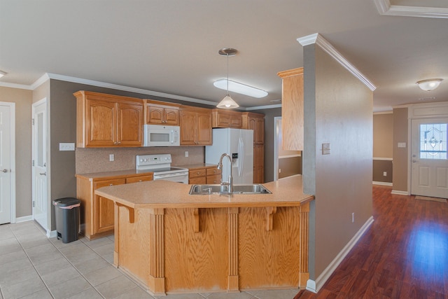 kitchen with white appliances, crown molding, sink, kitchen peninsula, and backsplash