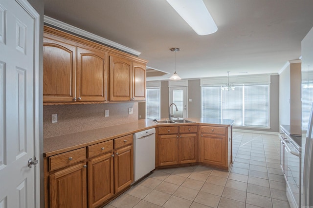 kitchen featuring kitchen peninsula, pendant lighting, sink, light tile patterned floors, and white appliances