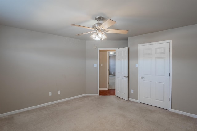 unfurnished bedroom with ceiling fan and light colored carpet