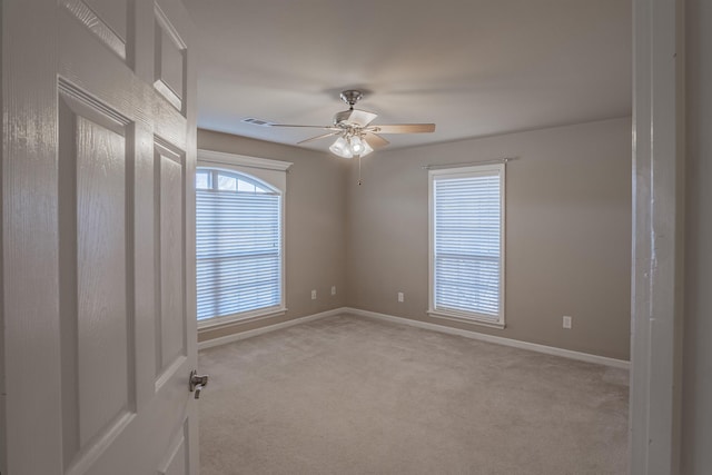 unfurnished room with ceiling fan and light carpet