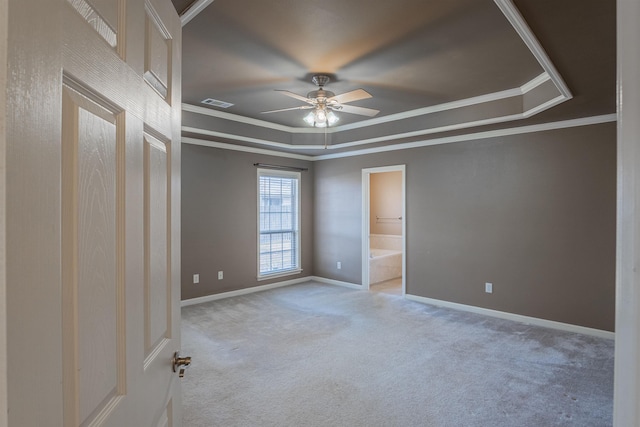 carpeted spare room with ceiling fan, a raised ceiling, and crown molding