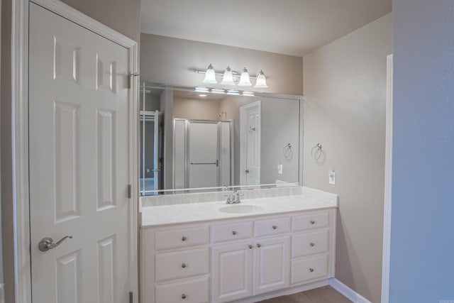 bathroom with vanity and a shower with door