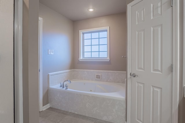 bathroom featuring tile patterned flooring and tiled tub