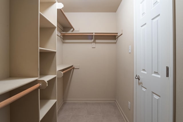 walk in closet with light tile patterned floors