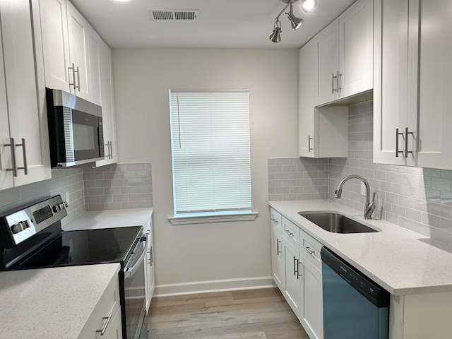 kitchen featuring sink, white cabinets, light stone countertops, and appliances with stainless steel finishes